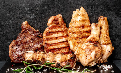 Various types of grilled meat, beef, pork, chicken on stone background
