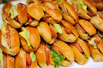 Stack of hotdog sandwiches, grilled sausages on a plate