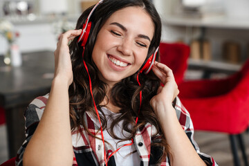 Happy nice woman listening music with headphones and smiling