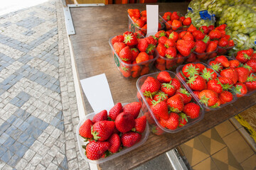 Fresh strawberries and grapes at outdoor market