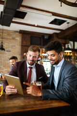 Confident business men talking and working together in a restaurant