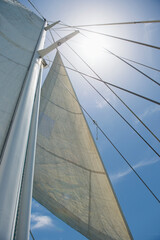 Low angle view of yacht sails and mast against sky