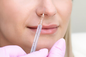 young woman receiving cosmetic injection. Woman in a beauty salon. Plastic Surgery Clinic.