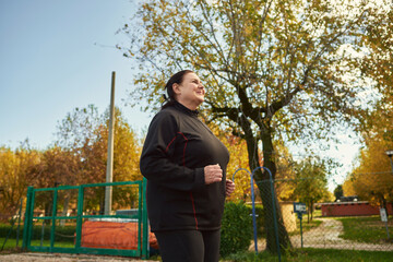 Active senior woman doing healthy exercises outdoors. Jogging