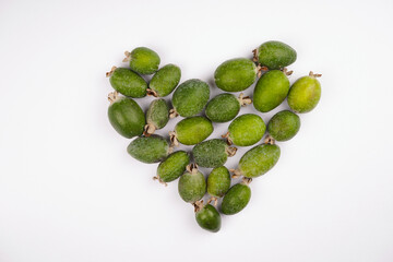 Feijoa heart shape on white background. Vitamin, immunity, recipe concept. Top view, copy space, flat lay