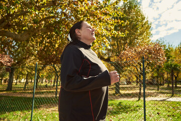 Active senior woman doing healthy exercises outdoors. Jogging
