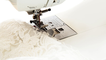 sewing machine with white guipure fabric close up