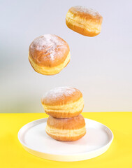 Donuts selection flying on yellow background selectiv focus. Various doughnuts isolated on colorful background