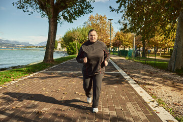 Active senior woman doing healthy exercises outdoors. Jogging