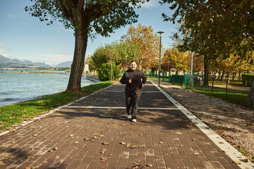 Active senior woman doing healthy exercises outdoors. Jogging