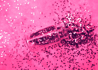 red Glitter pours from a bottle isolated on pink  background