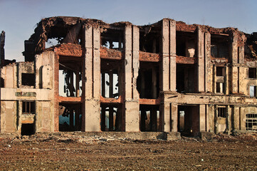 Landscape of ruined buildings at sunset, image of decrepitude or natural disaster.