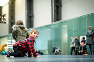 Crawling baby boy in red and black checkered shirt