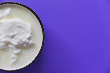close up of fresh yogurt in a bowl on color background 