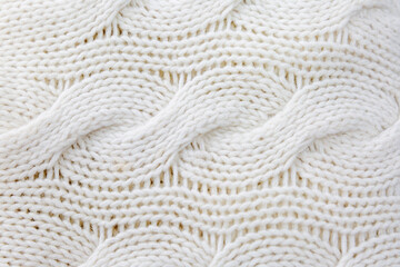 White wool knit with braids. Close-up. Background. Space for text. Hobby and craftsmanship.