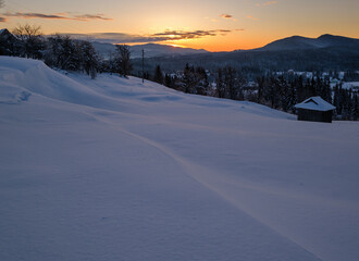 Small and quiet alpine village and winter sunrise snowy mountains around, Voronenko, Carpathian, Ukraine.