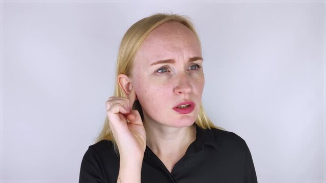 A woman suffers from pain in the ear. The auditory meatus hurts due to otitis media, cerumen plug, ear boil, or trigeminal neuralgia. On examination by a doctor.
