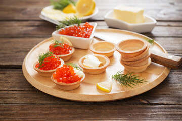cooking tartlets with red caviar on wooden table