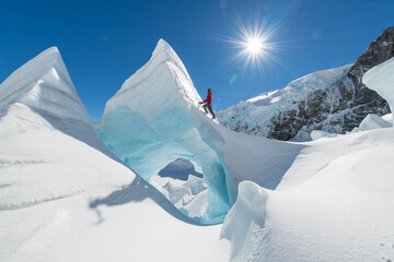 Man in red Ice climbing on The Tasman Glacier (Haupapa) which is the largest glacier in the Southern Alps, South Island, New Zealand. 