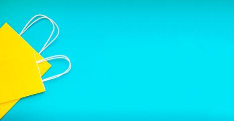 Yellow shopping bags over the blue background. Colorful flatly banner with space for text.