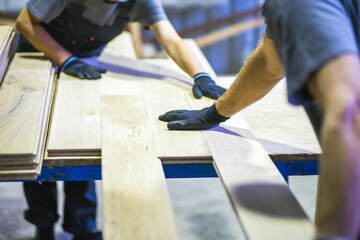 workers assembling wooden flooring in wood processing factory