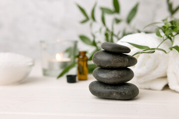 Fototapeta na wymiar hot stone massage - spa beauty treatment items on white wooden table