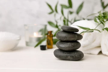 Fototapeten Hot-Stone-Massage - Spa-Beauty-Behandlungsartikel auf weißem Holztisch © ronstik