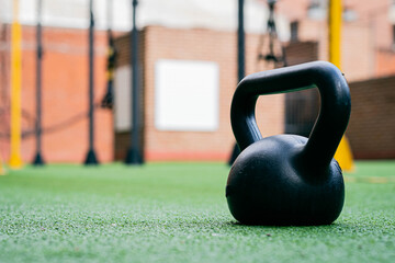 Obraz na płótnie Canvas pesa o mancuerna rusa de hierro y plástico en gimnasio fitness deporte físico sobre pasto sintético con espacio para texto cordoba argentina