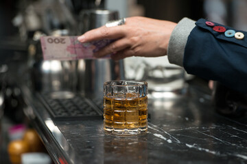 Woman man pays the bartender for the order with a cash