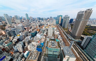 Aerial view of Tokyo Downtown with a beautiful city skyline under sunny sky, a high speed bullet train traveling on Shinkansen Railway & elevated Yurikamome Line running between high rise skyscrapers