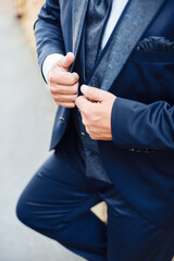 Groom is holding hands on the jacket , wedding suit