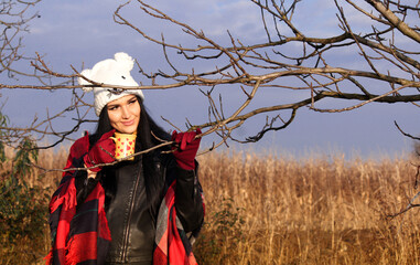 A portrait of a girl who enjoys a cup of hot drink in a natural autumn environment