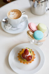 Fototapeta na wymiar Coffee and macarons desserts on a cafe table