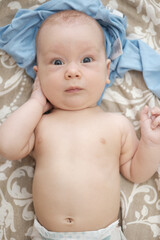 Cute little baby lying on bed and looking at the camera