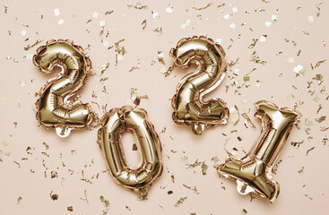 Shiny balloon symbols 2021 with glitters on festive background.