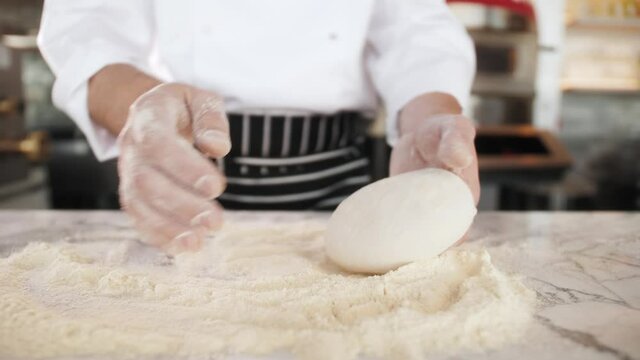 Italian chef making dough for pizza, traditional food, man working in restaurant kitchen, high cuisine, haute bakery