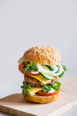 Delicious burger on grey background, selective focus, vertical orientation