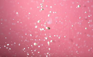Splashing milk on a pink background.