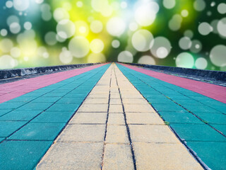 Colorful cobblestone bricks floor as pathway for jogging in the park with light spot bokeh as background. Goal concepts.