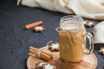 Pumpkin spiced latte or coffee in a cup on turquoise vintage background. Autumn, fall, or winter hot drink. Cozy breakfast or snack.