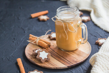 Pumpkin spiced latte or coffee in a cup on turquoise vintage background. Autumn, fall, or winter hot drink. Cozy breakfast or snack.