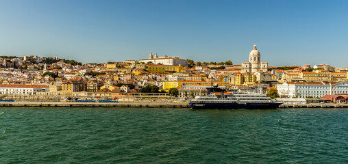 Naklejka premium A view of the old quarter and cruise terminal of Lisbon, Portugal from the Tagus river