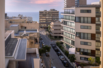 View of an old and new buildings in the city of Tel-Aviv, Israel. In the background – the Mediterranean Sea.