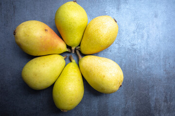 ripe pears on gray background, view from above, free space for edits