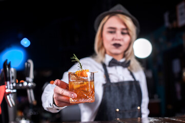Portrait of girl barman makes a show creating a cocktail