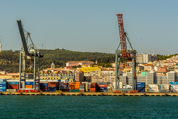 River traffic crossing the Tagus river with a backdrop of the old quarter, Lisbon, Portugal