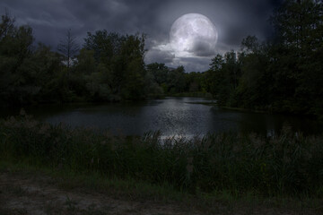 Full moon and cloudy sky over the night lake