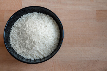 Rice in a bowl on wooden table background