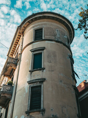 historic old rounded building with green wooden window shutters in the town with blue sky in the summer in croatia