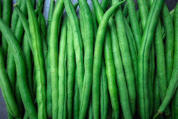 Green beans on grey stone background. Top view.
